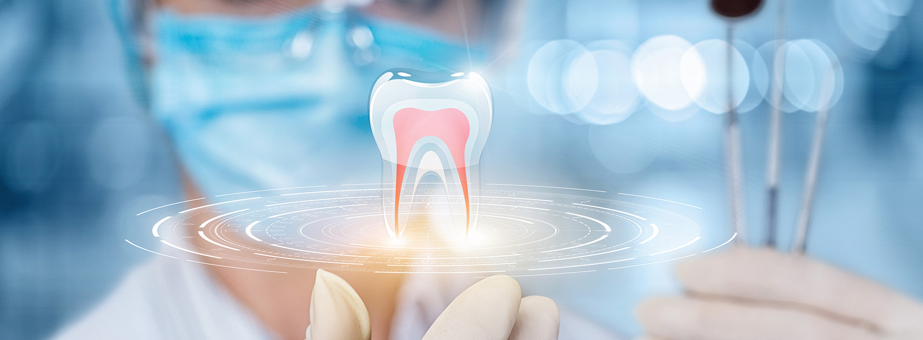 A person is seated in a dental chair, receiving care from a dental professional who stands behind them.